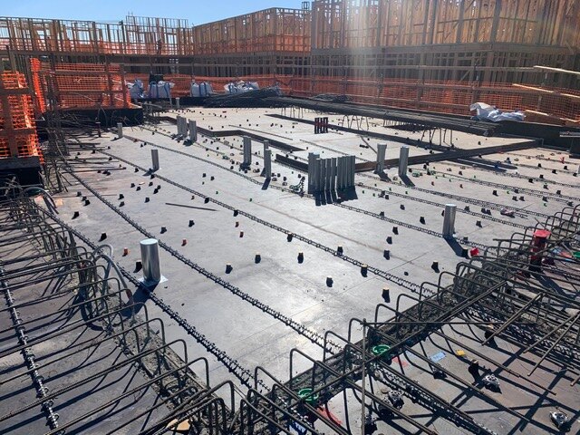 Precisely laid out plumbing penetrations and sleeves on a concrete deck before the next pour